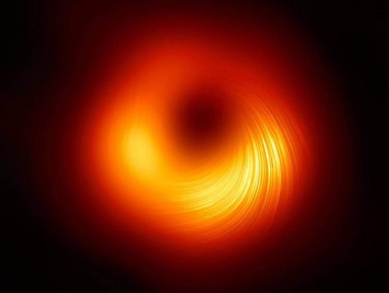 Immagine reale rielaborata che rappresenta l'orizzonte degli eventi, il buco nero, invisibile al centro
