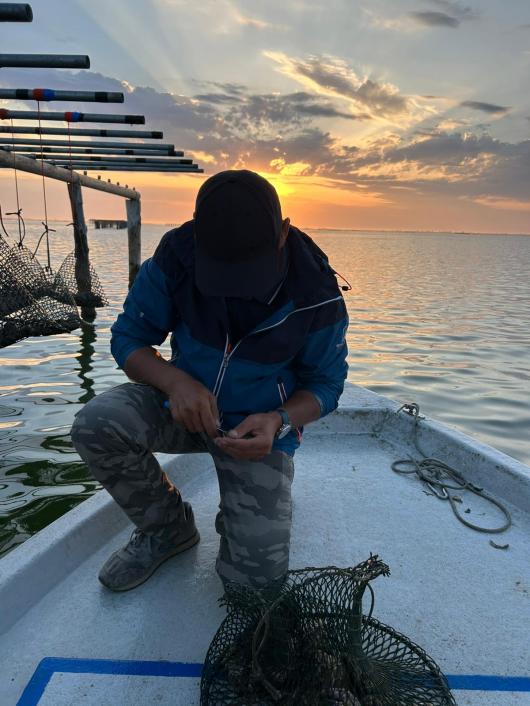 Il pescatore Diego intento ad aprire un'ostrica