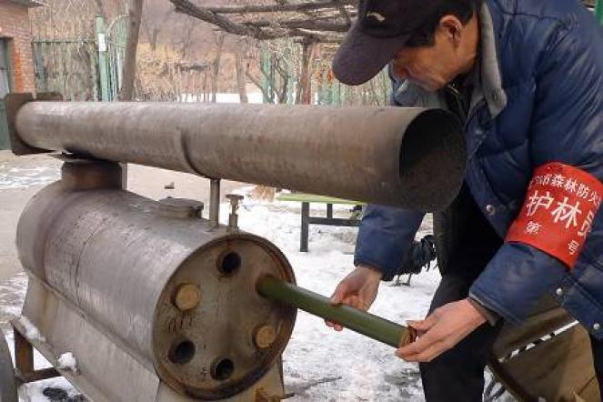 Un operaio cinese carica un cannone a ioduro di argento per ottenere la pioggia