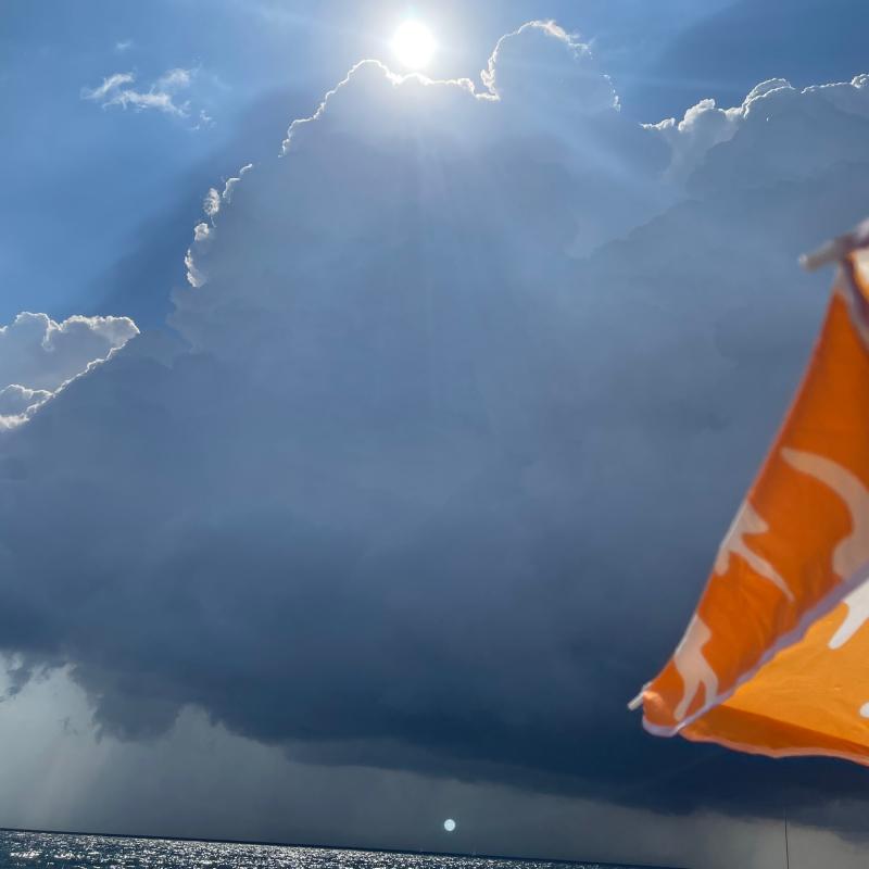 Nuvola nera sul mare nuvole bianche alle spalle