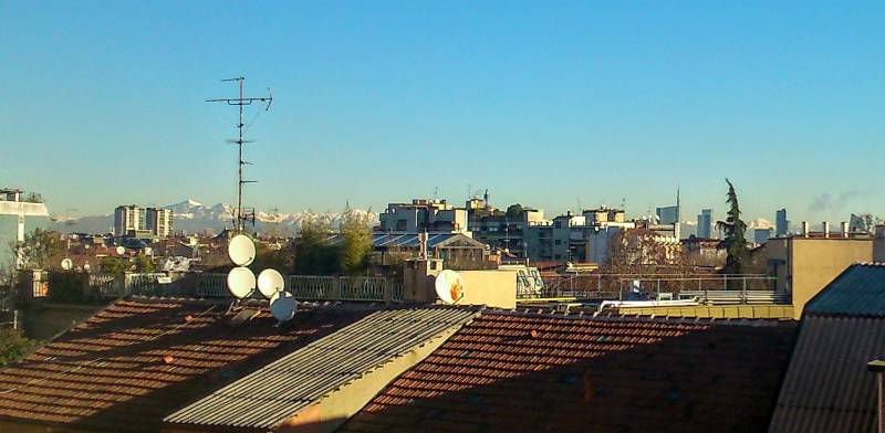 Prealpi sullo sfondo della skyline di Milano